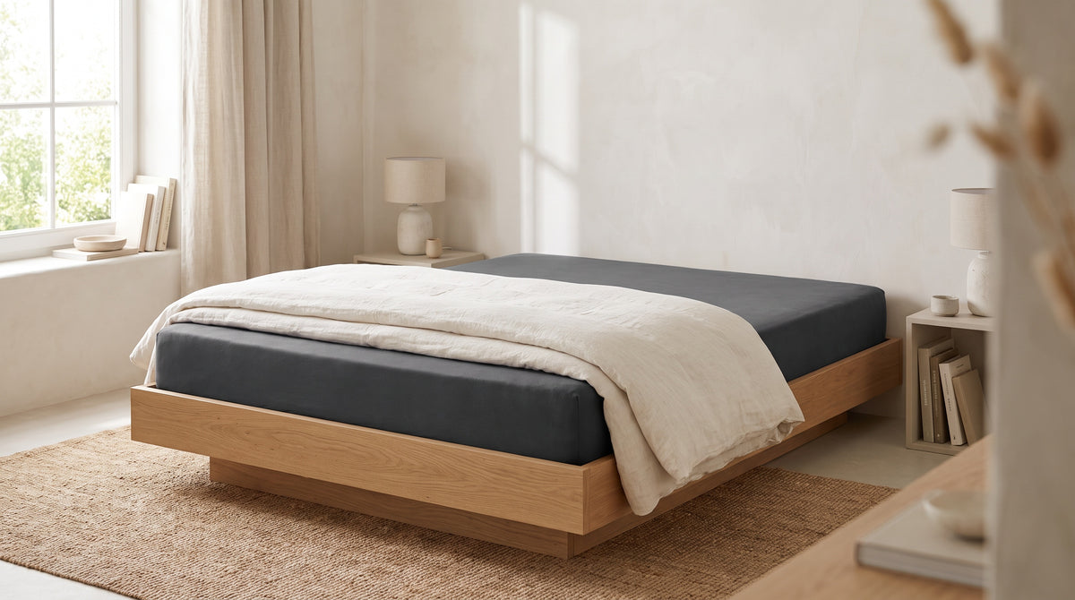 Helles Schlafzimmer mit Eichenbett und anthrazitfarbenem Jersey-Spannbettlaken
